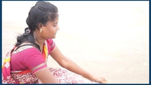An older woman indulges in explicit behavior on the shore with her moist genitalia