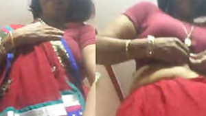 Desi female in a red sex sari flashes her XXX jugs changing the clothes